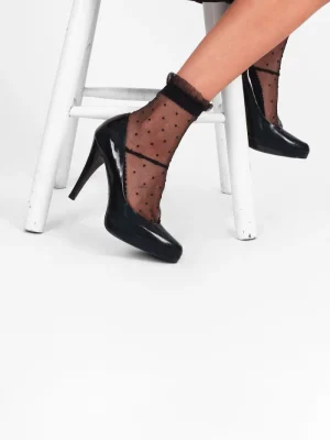 גרבי תחרה שחורות מנוקדות בסגנון רטרו משולבות עם נעלי עקב שחורות