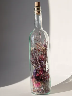 בקבוק יין מלא בפרחים יבשים ריחניים בצבע סגול