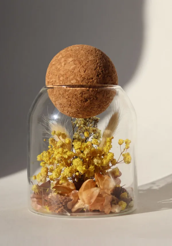 כלי זכוכית מעוצב ומלא בקוקטייל פרחים יבשים טבעיים בצבע צהוב, פקק שעם כדורי.