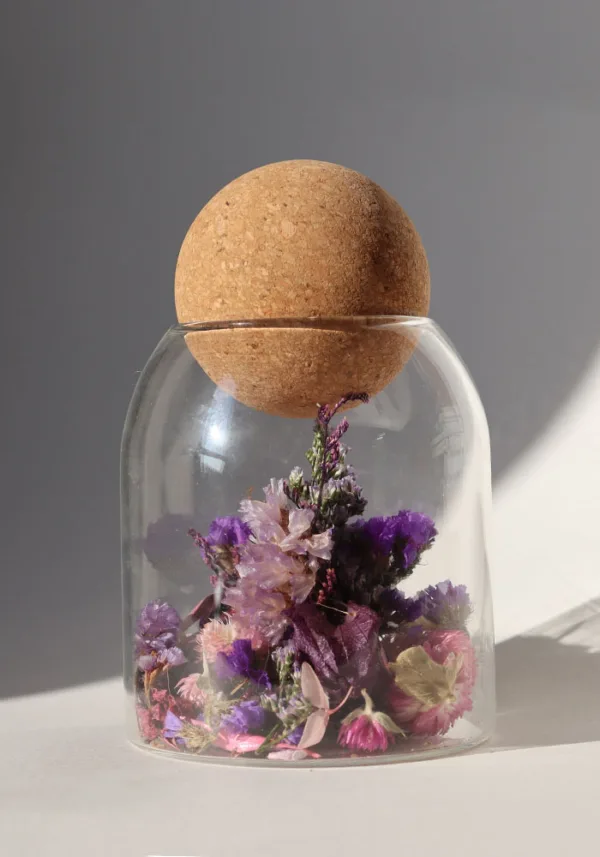 כלי זכוכית מעוצב ומלא בקוקטייל פרחים יבשים טבעיים בצבע סגול, פקק שעם כדורי.